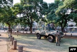 Anggota Pasukan Pertahanan Nasional Afrika Selatan (SANDF) berjaga di halaman selatan Gedung Persatuan di Pretoria, 20 Maret 2023 saat Afrika Selatan bersiap menghadapi protes setelah partai terbesar ketiga, Pejuang Kebebasan Ekonomi (EFF) menyerukan protes "penutupan nasional". (PHILL MAGAKOE/AFP)