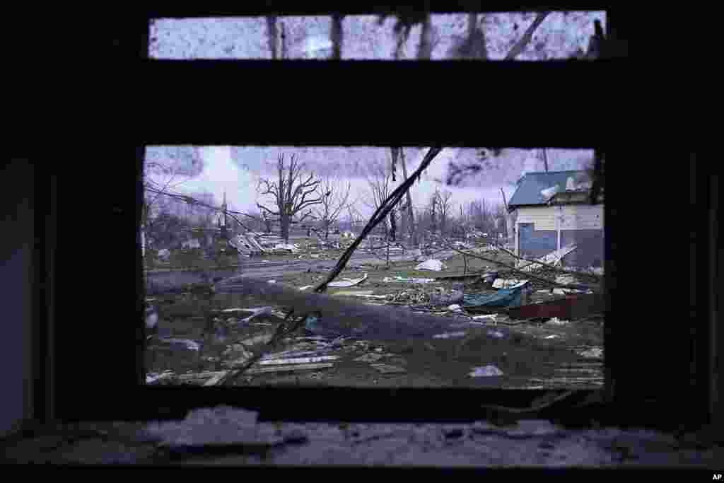 Debris is visible through the window of a damaged home following severe storms, in Lakeview, Ohio. 