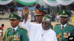 FILE - Nigeria's new President Bola Ahmed Tinubu inspects honor guards after taking an oath of office at a ceremony in Abuja, Nigeria, on May 29, 2023.