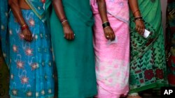 FILE- Indian women wait to cast their votes in Rajnandgaon, in the central Indian state of Chhattisgarh, April 17, 2014. 