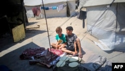 14일 가자지구 남부 라파에 난민 임시 대피소에서 아이들이 앉아있다.