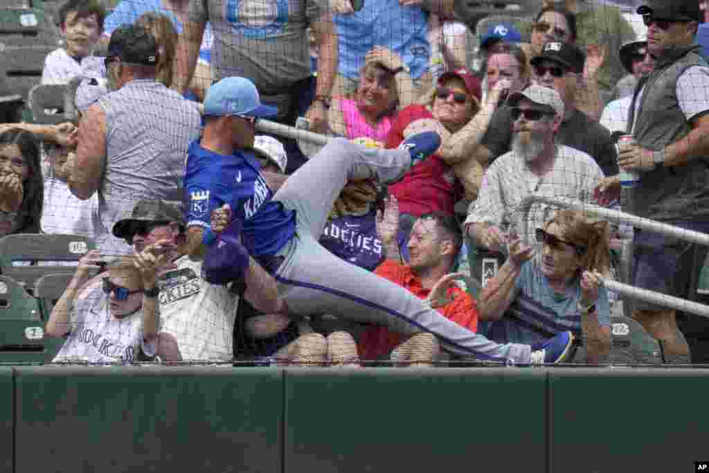 Kansas City Royals third baseman Nick Loftin crashes into the netting and the first row of fans as he failed to make a play on a foul ball hit by Colorado Rockies&#39; Nolan Jones during the second inning of a spring training baseball game, March 12, 2024, in Scottsdale, Arizona.