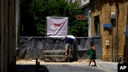 FILE - A tourist looks inside the U.N buffer zone in Nicosia, Cyprus, July 5, 2023. The island's division came about in 1974 when Turkey invaded in the wake of a coup aimed at union with Greece.