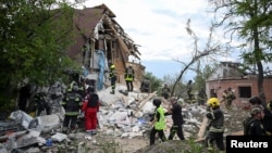 Rescuers work at a site of a private house destroyed during a Russian air strike in Kharkiv, Ukraine, June 10, 2024.