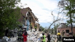 乌克兰救援人员在哈尔科夫被俄军空袭炸毁的一座民宅展开救援工作。（2024年6月10日）