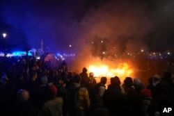 Demonstrators gather next to a burning barricade as they stage a protest in Paris, Friday, March 17, 2023.