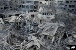 Palestinians inspect the rubble of the Yassin Mosque destroyed after it was hit by an Israeli airstrike at Shati refugee camp in Gaza City, Oct. 9, 2023.