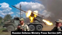 FILE - Photo taken from video released by the Russian Defense Ministry, July 1, 2024, Russian soldiers fire from the BM-21 'Grad' self-propelled 122mm multiple rocket launcher in undisclosed location.
