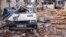 Cats sit in rubble front of a destroyed car at a damaged street after a 6.4-magnitude quake hit the Hatay province in southern Turkey, in Antakya, Feb. 21, 2023.