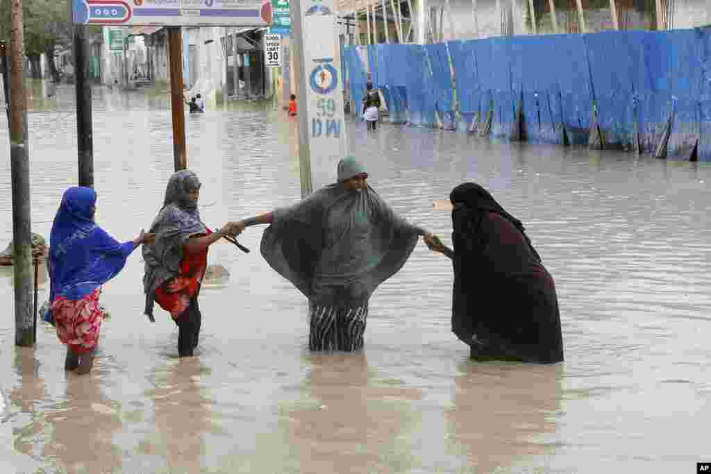 Women walk through flood water after heavy rainfall, in Mogadishu Somalia, Monday, November 20, 2023.&nbsp;