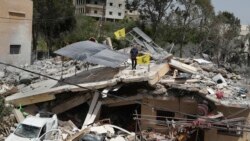 Seorang pria tampak berdiri di atas reruntuhan rumah yang hancur akibat serangan Israel di desa Hanine, di selatan Lebanon, pada 25 April 2024. (Foto: AP/Mohammed Zaatari)