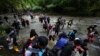 Migran, kebanyakan warga Venezuela, menyeberangi sungai saat melewati Darien Gap dari Kolombia ke Panama, berharap bisa mencapai AS, 15 Oktober 2022. (Foto: AP)