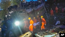 ওড়িশার বালাসোর জেলায় যাত্রীবাহী ট্রেন লাইনচ্যুত হবার পর উদ্ধারকর্মীরা এক ব্যক্তির মরদেহ বহন করছে। ( ৩ জুন, ২০২৩)