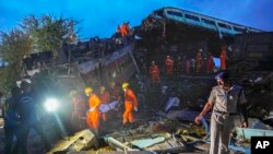 Rescuers carry the body of a victim at the site of passenger trains that derailed in Balasore district, in the eastern Indian state of Orissa, June 3, 2023. 