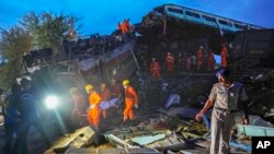 Rescuers carry the body of a victim at the site of passenger trains that derailed in Balasore district, in the eastern Indian state of Odisha, June 3, 2023. 