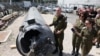 Israeli military spokesman Rear Admiral Daniel Hagari and other members of the Israeli military stand next to an Iranian ballistic missile which fell in Israel on the weekend, during a media tour at the Julis military base, April 16, 2024. 