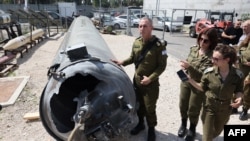 Israeli military spokesman Rear Admiral Daniel Hagari and other members of the Israeli military stand next to an Iranian ballistic missile which fell in Israel on the weekend, during a media tour at the Julis military base, April 16, 2024. 