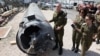 Israeli military spokesman Rear Admiral Daniel Hagari and other members of the Israeli military stand next to an Iranian ballistic missile which fell in Israel on the weekend, during a media tour at the Julis military base, April 16, 2024. 