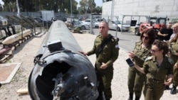 Portparol izraelske vojske kontraadmiral Daniel Hagari i drugi pripadnici izraelske vojske stoje pored iranske balističke rakete koja je pala u Izrael tokom vikenda.
