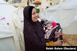 Yasmine Saleh menggendong bayi perempuannya Toleen, yang lahir saat konflik antara Israel dan Hamas, di luar tenda tempat mereka berlindung di Rafah di Jalur Gaza selatan, 17 Desember 2023 .(Foto: REUTERS/Saleh Salem)