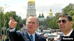 Архівне фото: Колишній президент США Джордж Буш (ліворуч) з Джоном Гербстом, тогочасним послом США в Україні, під час прогулянки центром Києва в травні 2004 року. REUTERS/Pool 