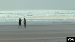 Walkers on the beach in St. Augustine, Florida, Feb. 28, 2023. (Photo by Adam Greenbaum/VOA) 