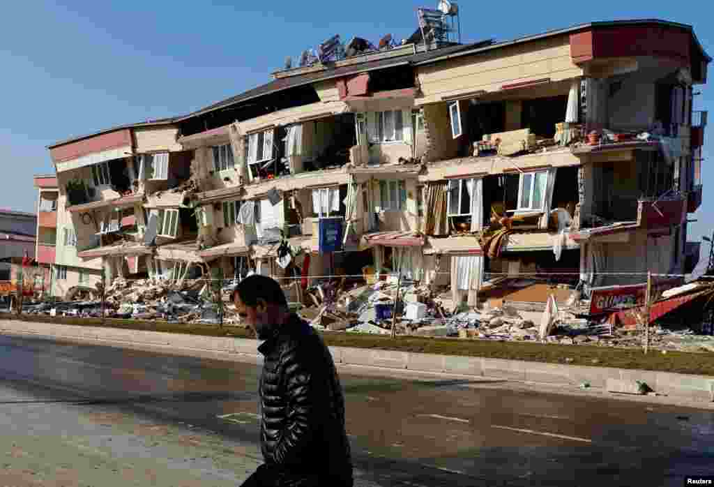 Човек поминува покрај оштетена зграда како последица на смртоносниот земјотрес во Кахраманмарас, Турција.
