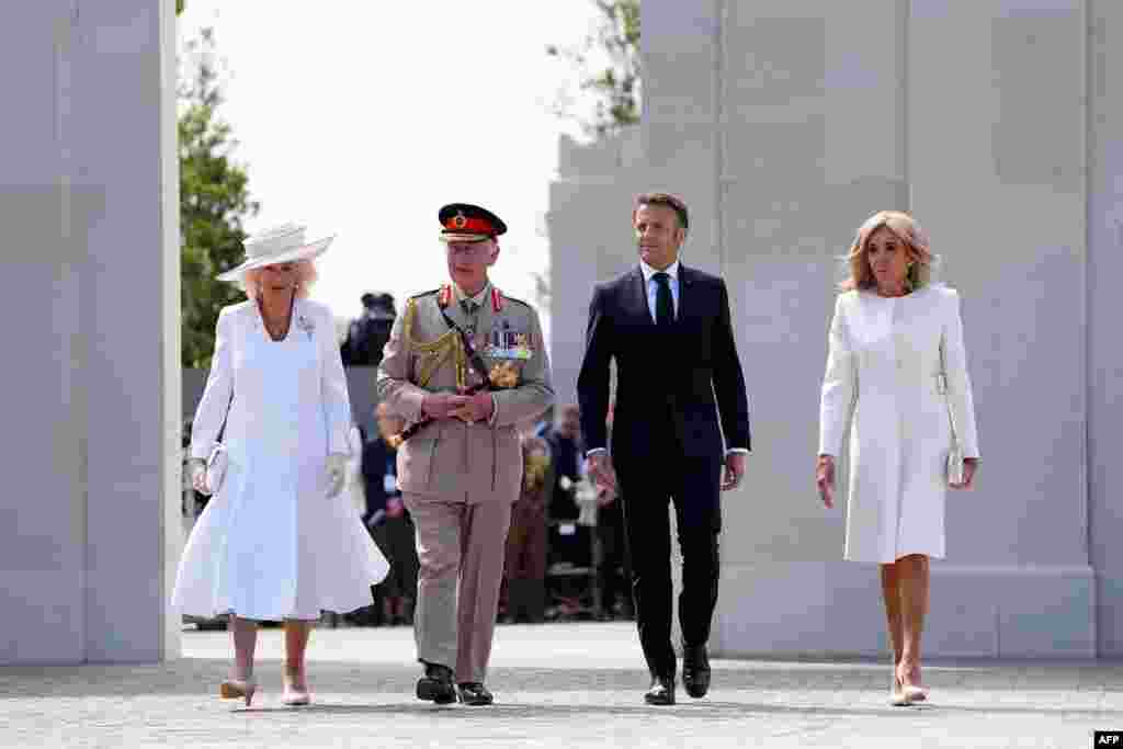 O rei Carlos III da Grã-Bretanha e sua esposa, a rainha Camilla (esq) caminhando com o Presidente da França Emmanuel Macron e a sua esposa Brigitte Macron (dir) passam pelo muro memorial durante a cerimónia comemorativa do Ministério da Defesa do Reino Unido e da Legião Real Britânica marcando o 80&ordm; aniversário dos desembarques dos aliados do &quot;Dia D&quot; da Segunda Guerra Mundial na Normandia, no Memorial da Normandia Britânica da Segunda Guerra Mundial, perto da vila de Ver-sur-Mer, no noroeste da França, 6 de junho de 2024.