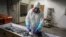 FILE - An employee takes the fingerprints of a coronavirus victim prior to her cremation in Santiago, Chile, June 27, 2020. Countries are still struggling to devise a plan for how the world might respond to the next global outbreak.
