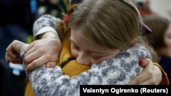 Dijete koje je odvedeno u Rusiju grli majku nakon povratka preko ukrajinsko-bjeloruske granice.