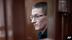 Robert Woodland, a Russia-born U.S. citizen, stands in a glass cage during a court hearing, July 4, 2024, in Moscow, Russia.