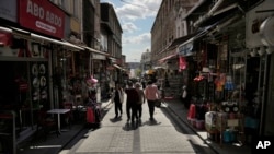 FILE - People walk in a public market in the Fatih district of Istanbul, Turkey, April 29, 2023. Syrians fleeing their country's civil war were once welcomed in Turkey out of compassion, but as their numbers grew, so did calls for their return.