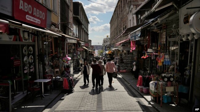 FILE - People walk in a public market in the Fatih district of Istanbul, Turkey, April 29, 2023. Syrians fleeing their country's civil war were once welcomed in Turkey out of compassion, but as their numbers grew, so did calls for their return.