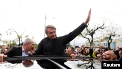 Mantan Presiden Brazil Jair Bolsonaro melambaikan tangan untuk para pendukungnya di Bandara Internasional Salgado Filho, setibanya di Porto Alegre, Rio Grande do Sul, Brazil, 22 Juni 2023.