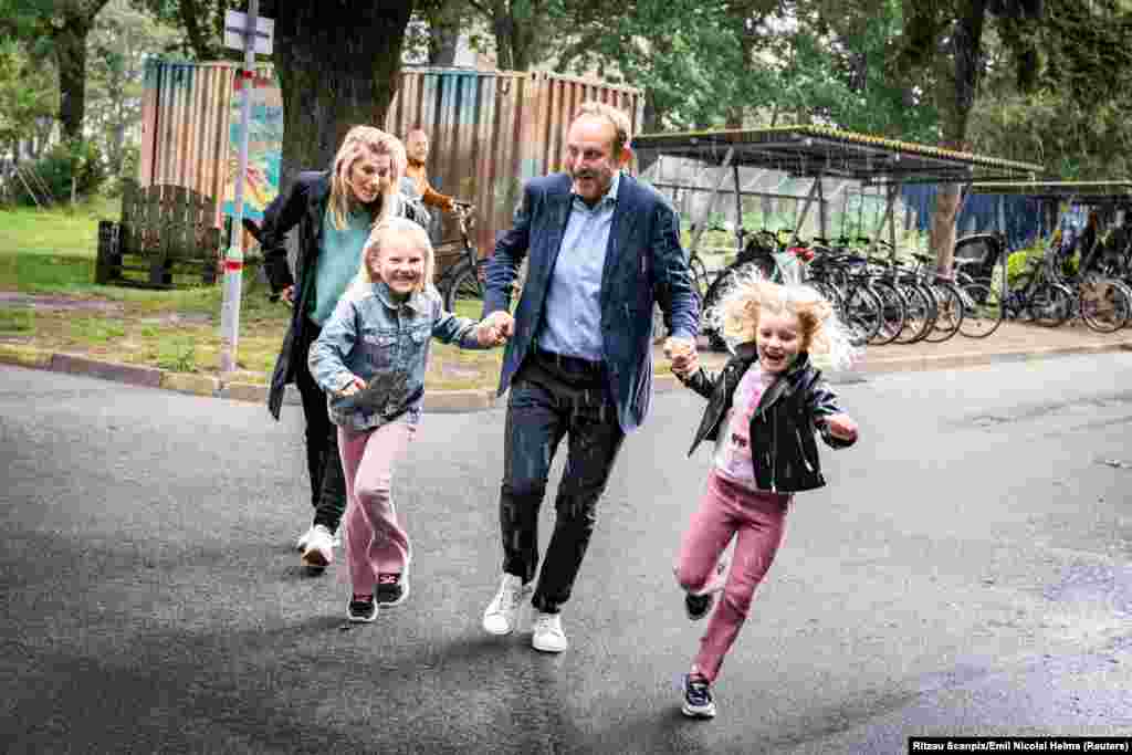 Danish leader of the Social Liberal Party Martin Lidegaard and his family are caught in the rain as they attend the European Parliament election at a polling station, in Copenhagen, Denmark, June 9, 2024. 