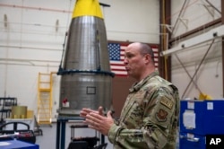 In this image provided by the U.S. Air Force, Chief Master Sgt. Andrew Zahm speaks in front of the top of a Minuteman III intercontinental ballistic missle shroud at F.E. Warren Air Force Base, Wyo., Aug. 16, 2023.