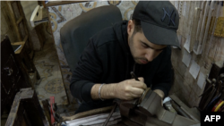 Mohamed Amine Htiouich, a craftsman engraver working on an object in Tunis, Tunisia on December 8, 2023