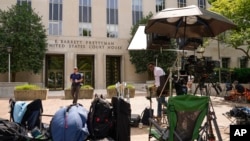 Members of the media linger outside E. Barrett Prettyman U.S. Federal Courthouse, Aug. 2, 2023, in Washington. Former President Donald Trump is due in court on Thursday.