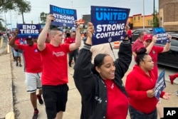 File - United Auto Workers members march at a union rally held near a Stellantis factory, Aug. 23, 2023, in Detroit, Michigan.