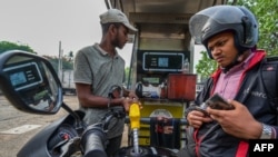 A worker fills petrol in an motorbike at a fuel station on March 21, 2023.