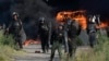 Police officers throw stones towards supporters of Pakistan's former Prime Minister Imran Khan during clashes, in Islamabad, Pakistan, May 10, 2023.