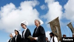People take part in a traditional religious forgiveness of Notre-Dame de la Clarte on the feast day of the Assumption of Mary in Perros-Guirec, France.