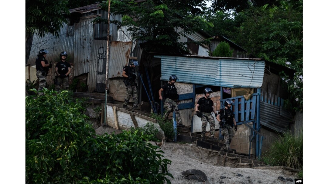 Polisi berjaga selama operasi pembongkaran kota kumuh distrik "Talus 2" di Koungou, pulau Mayotte milik Prancis di Samudra Hindia, 22 Mei 2023. (Philippe LOPEZ/AFP)