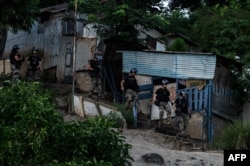 Polisi berjaga selama operasi pembongkaran kota kumuh distrik "Talus 2" di Koungou, pulau Mayotte milik Prancis di Samudra Hindia, 22 Mei 2023. (Philippe LOPEZ/AFP)
