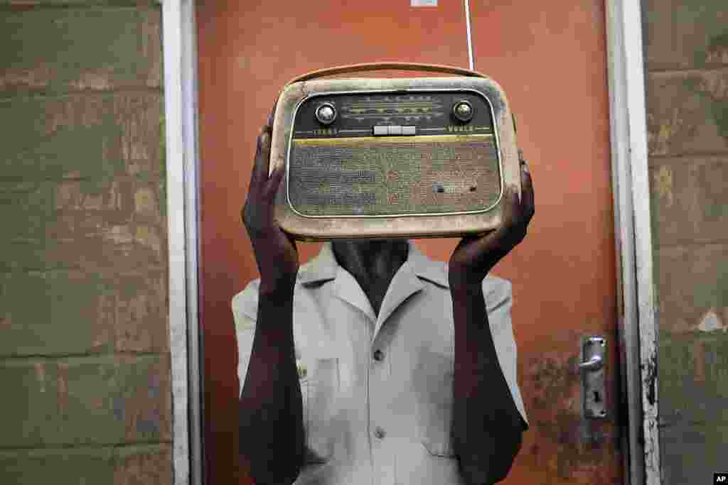 Ngwiza Khumbulani Moyo, a vintage collector holds an old radio set outside his home in Bulawayo, Wednesday, February 15, 2023. According to a survey by Afrobarometer, radio is &quot;overwhelmingly&quot; the most common source of news in Africa.&nbsp;