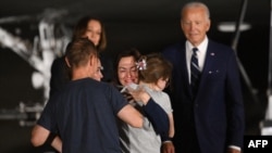 US President Joe Biden and Vice President Kamala Harris watch US-Russian journalist Alsu Kurmasheva, just released from Russia, embraces her family as she arrives at Joint Base Andrews in Maryland on Aug. 1, 2024. 