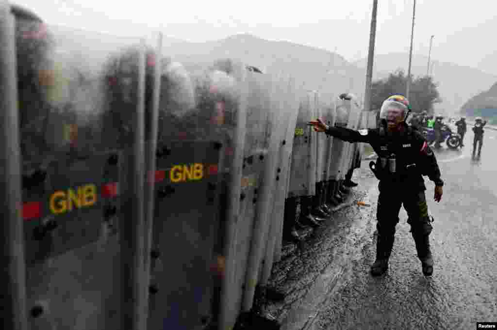 La policía antidisturbios hace guardia tras los enfrentamientos con los manifestantes&nbsp;durante un bloqueo de carreteras, contra los resultados de las elecciones, después de que el presidente Nicolás Maduro proclamara la victoria en las elecciones presidenciales del domingo en Caracas.