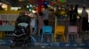 An elderly man rests against a baby stroller at an amusement park during International Children's Day in Beijing, June 1, 2021. 