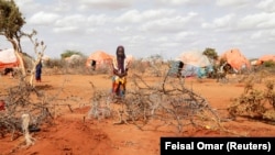 A young girl stands near the grave of her twin sisters who died of hunger in Somalia.