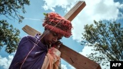 Brolyne Befany Joseph, 14 ans, joue le rôle de Jésus-Christ lors d'une reconstitution de la Passion du Christ par des fidèles de l'église catholique Notre-Dame de Lourdes lors de leur procession du Vendredi Saint dans le bidonville de Kibera, à Nairobi, le 7 avril 2023.